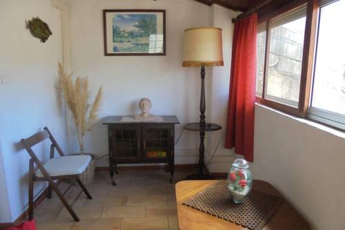 un salon avec une table, une lampe et une chaise dans l'établissement Maison Chaberlin, à Malaucène