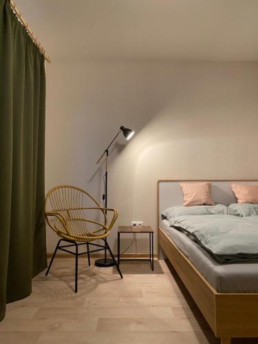 a bedroom with a bed and a chair and a lamp at Panorama Home Valča in Stará Turá
