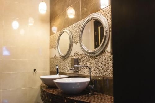 a bathroom with two sinks and two mirrors on the wall at Riviera in Klesiv