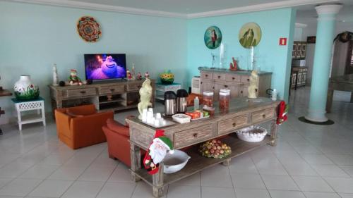 salon z kanapą i telewizorem w obiekcie Jequitiba Hotel Frente ao Mar w mieście Guarujá
