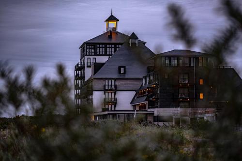 a large building with a tower on top of it at Strandhotel in Cadzand-Bad