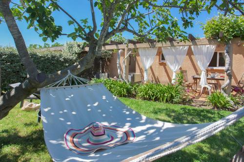 eine Hängematte, die von einem Baum im Hof hängt in der Unterkunft maison kiwi avec piscine chauffée terrasse jardin et bbq à Calvi in Calvi