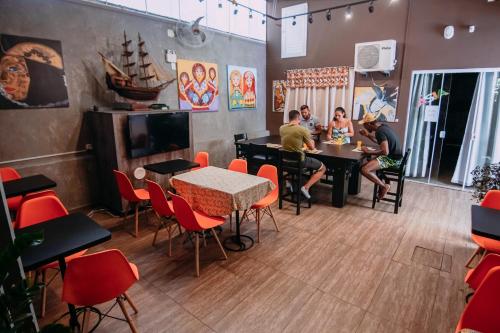 a group of people sitting at tables in a restaurant at Bonabrigo Hostel & Suítes in Balneário Camboriú