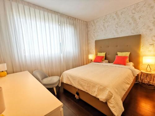 ein Schlafzimmer mit einem großen Bett mit roten Kissen in der Unterkunft Bom dia Parque Nações LisboaX in Lissabon
