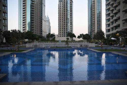 a large swimming pool in a city with tall buildings at TOWER 2 DOWNTOWN APARTMENT 29 BOULEVARD in Dubai