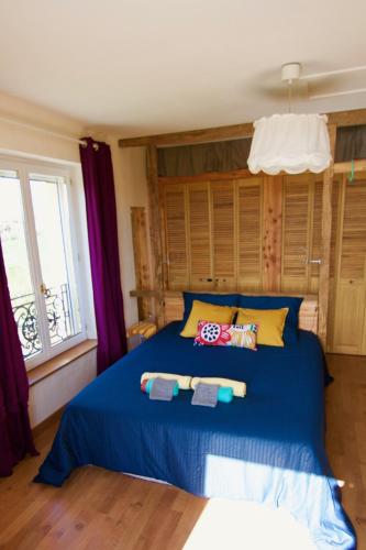 une chambre avec un lit bleu avec des serviettes dessus dans l'établissement Les zygotes, au coeur du Périgord Noir, à Plazac