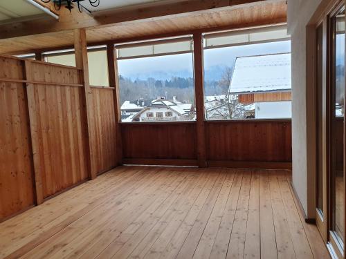 an empty room with a large window and a wooden floor at Ampio appartamento su 2 livelli con garage coperto in Valdaora