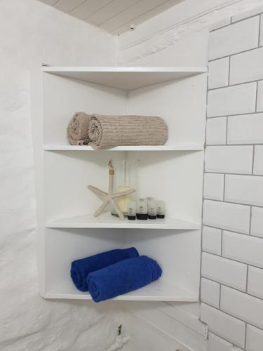 a bathroom with white shelves with towels and a starfish at 59 LongSantos in Mossel Bay