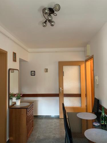 ヘーヴィーズにあるKőnig apartmanのテーブルと椅子2脚、テーブル1台が備わる客室です。