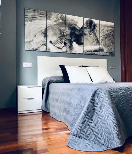 a bedroom with a bed with three paintings on the wall at lucushouse II in Lugo