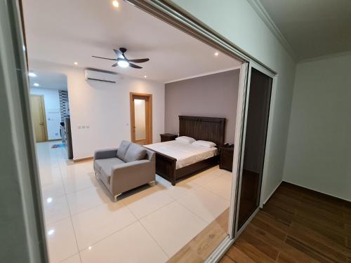 a bedroom with a bed and a couch and a chair at Royale Suites by Arc Royal Luxury Apts in Anse Royale