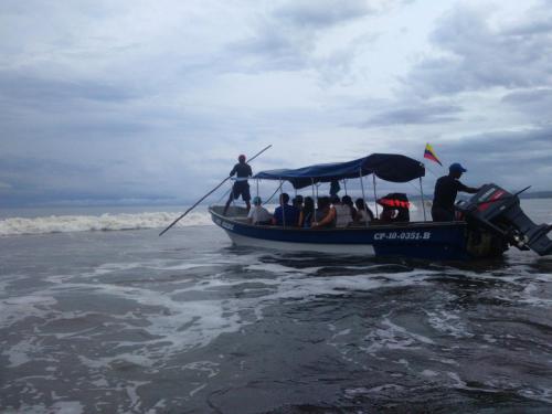a group of people on a boat on the beach at Cabaña Villa Sofi in Nuquí