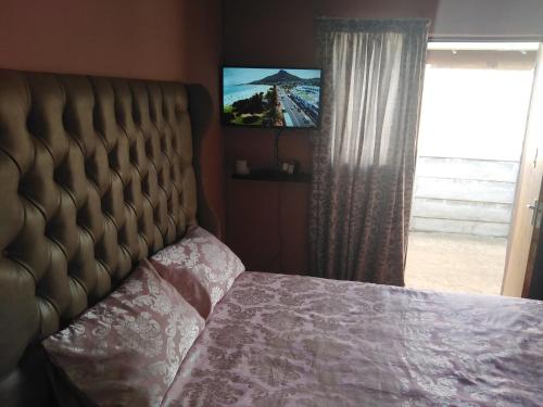 Schlafzimmer mit einem Bett, einem TV und einem Fenster in der Unterkunft Coolden guesthouse in Vanderbijlpark
