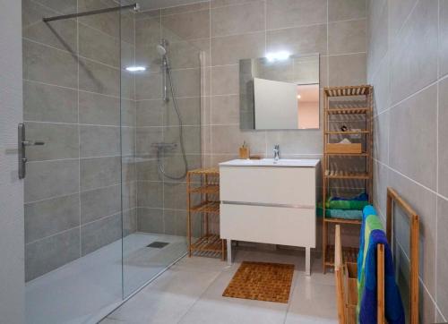 uma casa de banho com um chuveiro, um lavatório e um espelho. em Spécial Golf Appartement de 2 à 4 pers Classé 4 étoiles em Saint-Raphaël