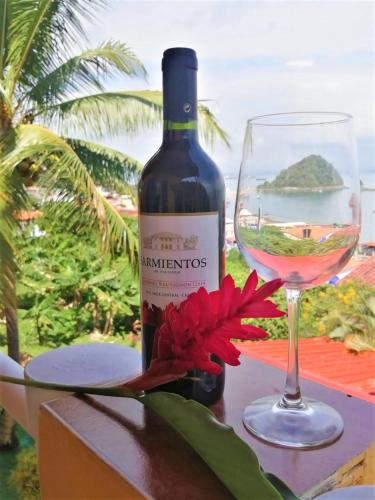 a bottle of wine and a glass on a table at Cerrito Tropical Eco Lodge in Taboga