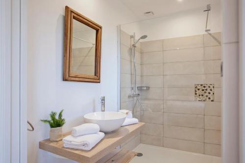 une salle de bain avec un lavabo et une douche dans l'établissement Palmier appartement de vacances 3 chambres piscine commune chauffée, à Calvi