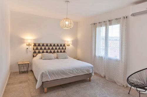 - une chambre blanche avec un lit et une fenêtre dans l'établissement Palmier appartement de vacances 3 chambres piscine commune chauffée, à Calvi