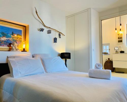 a bedroom with a white bed with a large window at Charmant T2 Cosy Notre Dame du Port in Clermont-Ferrand