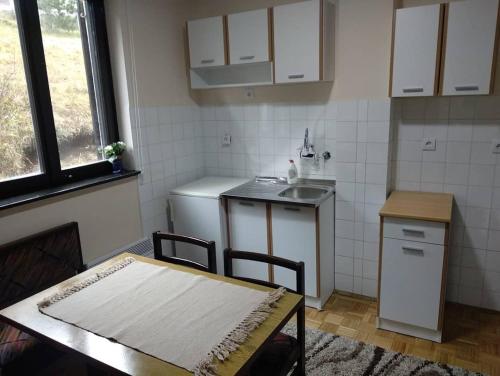 eine kleine Küche mit Tisch und Spüle in der Unterkunft Studio Veve Lux in Zlatibor