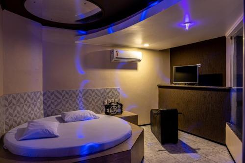 Un dormitorio con una cama con luces azules. en Fada Hotel - Motel Adults Only en Recife