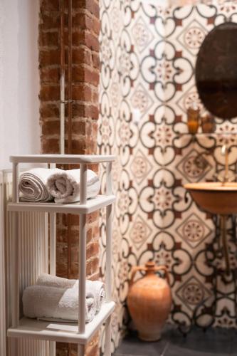 a room with two shelves with towels and a wall at Four Season Maison in Kavála