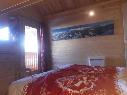 1 dormitorio con 1 cama con una foto en la pared en La Plagne Chalet cosy calme proche valée, en La Plagne Tarentaise
