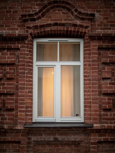 a white window on a brick building at RUMI Hotel with Self Check-In in Jēkabpils