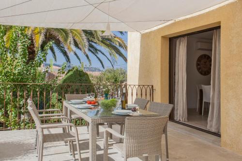 une table et des chaises sur un balcon avec un parasol dans l'établissement Appartement de vacances Arbousier à Calvi piscine chauffée partagée bbq, à Calvi