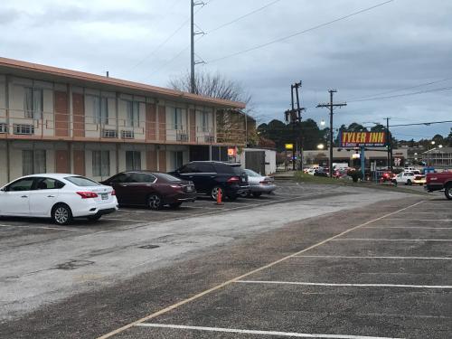 ein Parkplatz mit Autos vor dem Hotel in der Unterkunft Tyler Inn & Suites in Tyler