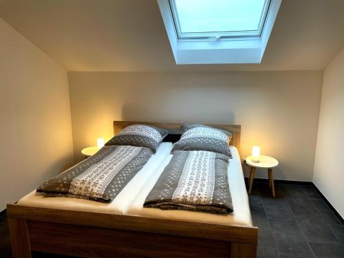 1 Schlafzimmer mit 2 Betten mit Kissen und einem Fenster in der Unterkunft Gästehaus Veenstra in Kelberg