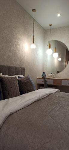 a bedroom with a bed and a mirror and lights at Citylife Boutique Hotel in Kharkiv