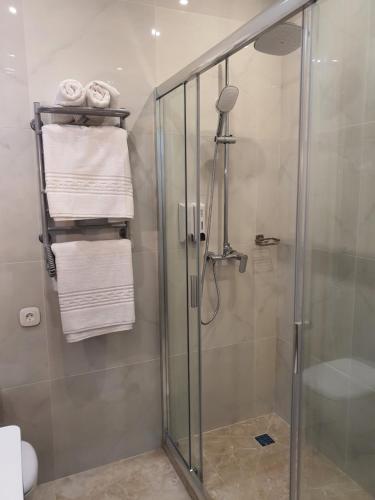 a bathroom with a shower with white towels at Citylife Boutique Hotel in Kharkiv