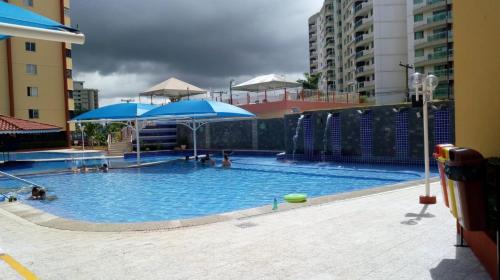una gran piscina con sombrillas azules en un edificio en CALDAS NOVAS - FLAT PARQUE DAS ÁGUAS QUENTES - As piscinas mais quentes de Caldas!!, en Caldas Novas