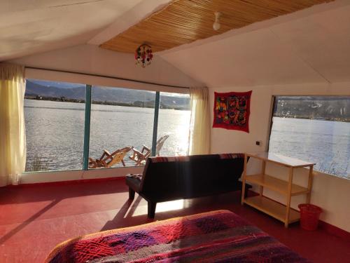 a living room with a view of the water at Uros Quechua`s Lodge Titicaca in Puno