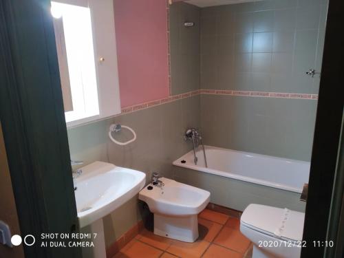 een badkamer met een toilet, een bad en een wastafel bij Estudio Edificio Salvia zona remontes in Sierra Nevada
