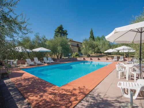 una piscina con sillas y sombrilla en Belvilla by OYO Casalini 2 en Romola
