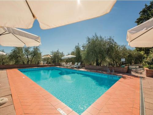 una piscina con sombrillas en un patio en Belvilla by OYO Casalini 2 en Romola