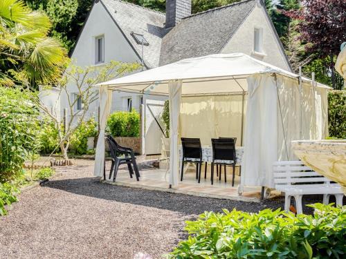 a white gazebo with chairs in a yard at Holiday home in Brittany near the sea in Pénestin