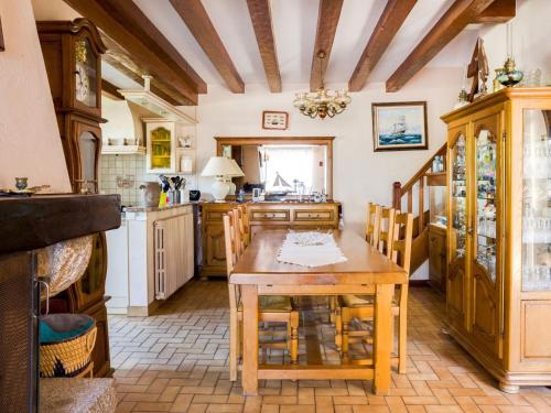 ペネスタンにあるHoliday home in Brittany near the seaの木製テーブルと椅子付きの広いキッチン