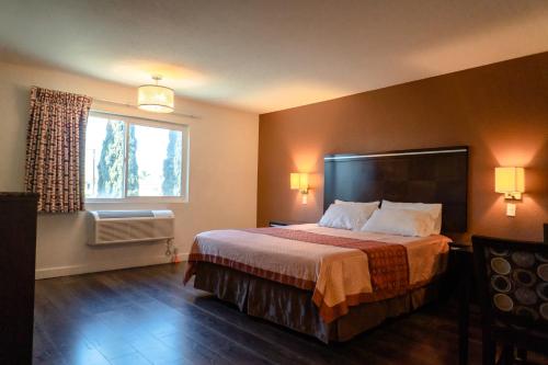 a hotel room with a bed and a window at Maywood Inn in Maywood