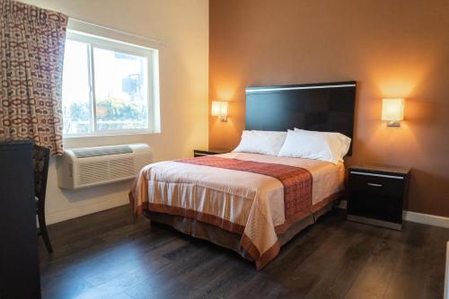 a hotel room with a bed and a window at Maywood Inn in Maywood