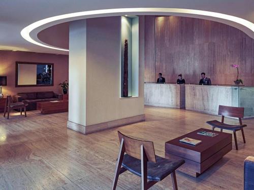 a lobby with people sitting at a bar in a building at Oft Alfre hotels - Goiânia in Goiânia