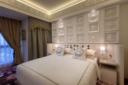 a bedroom with a large white bed with pillows at arte by Thomas Chan in Kuala Lumpur