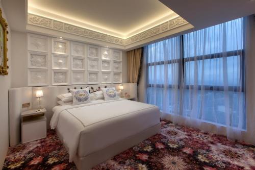 a bedroom with a white bed and a large window at arte by Thomas Chan in Kuala Lumpur