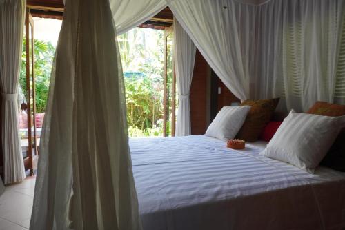 a bedroom with a white bed with a canopy at HIDDEN HEAVEN Rumah Barong in Jasri