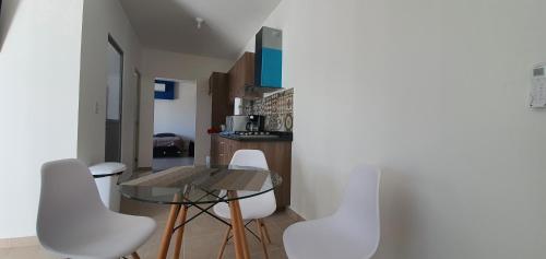 a dining room with a table and white chairs at Loft 10 min from Oro &Holy Beach, Marina, Galerias in Puerto Vallarta