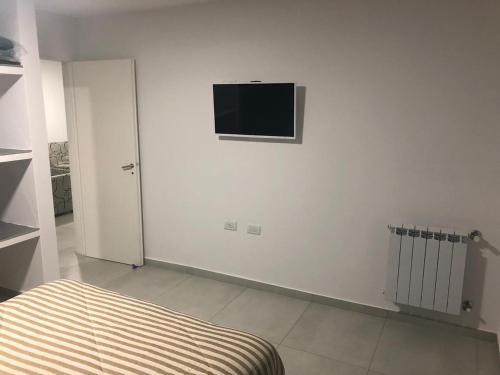 Habitación blanca con TV en la pared en Departamento Piamonte, en Monte Hermoso