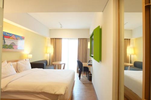 a hotel room with a bed and a desk at G'Sign Style Hotel in Kuta