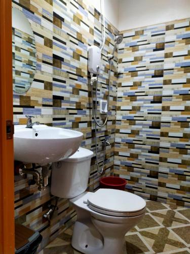 a bathroom with a toilet and a sink at Pacifico Seaside Lodge in Moalboal