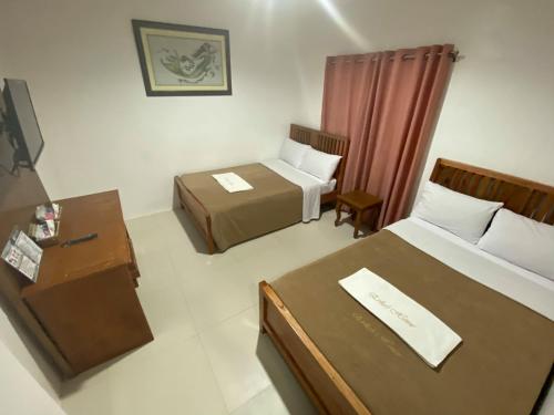 a hotel room with two beds and a desk at Eriko's House in Boracay